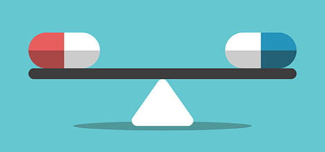 Red and blue pills balanced on scale